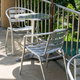 A small chair and table set of aluminum furniture.