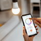 hand using phone to control smart light