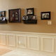 hallway with wainscoting and pictures on a wall