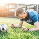 man doing pushups in a fenced in yard with weights