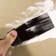 hand applying putty to wall with putty knife