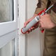 Silicone caulk being used to seal around a window.