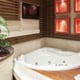 bathroom with jacuzzi tub, fern plant, and red tile