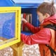 a child reaching into a little book library