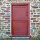 Red Dutch door against a brick exterior