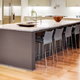 large kitchen island with sink and chairs over wooden floors