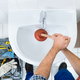 handyman unclogging sink with plunger