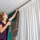 woman hanging drapes