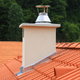 A red tile roof with a chimney and roof flashing. 