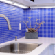 a kitchen with blue tile backsplash
