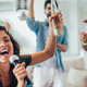 young friends singing karaoke together at a party