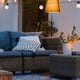 natural wicker furniture on a patio or deck with string lights