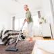 A woman vacuuming a carpet