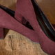 A pair of wine colored high heeled shoes made from suede.