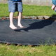 Two kids bouncing on a sunken trampoline.