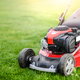 person pushing lawnmower over grass
