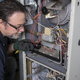 A repair technician fixing a furnace.
