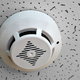 A smoke detector in a drop ceiling.