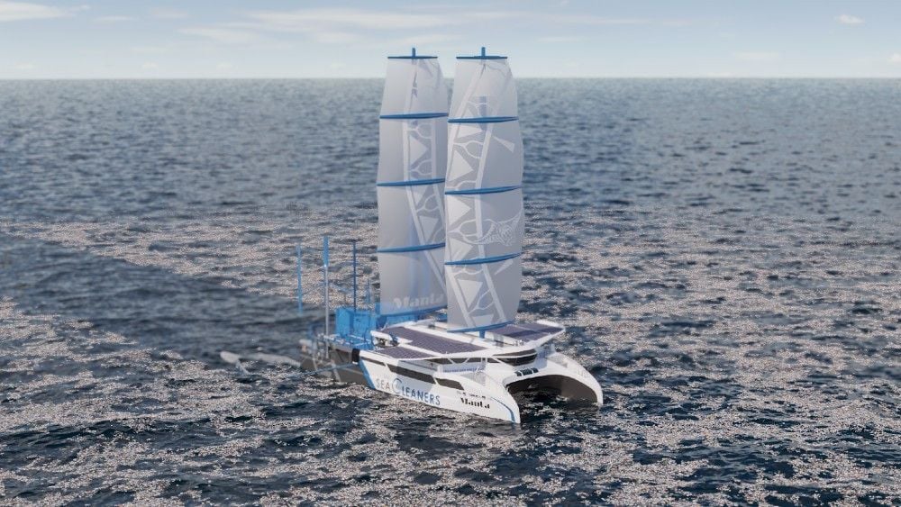 The Manta trash-eating yacht sails the open seas, sails fully open.
