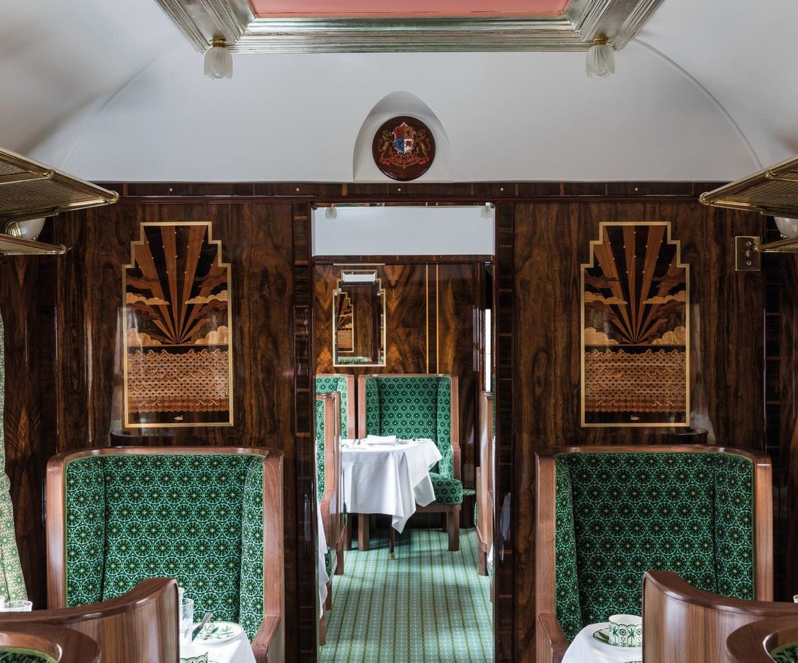 Emerald geometric upholstery and kitschy wood details adorn the interiors of Anderson's restored Cygnus train carriage.  