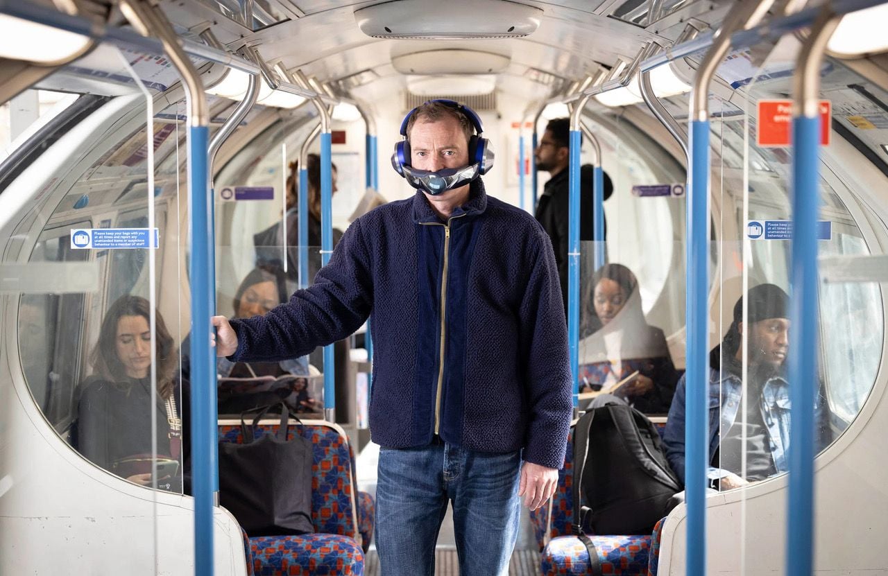 Man stands on the subway wearing the Dyson Zone air purifying headphones.