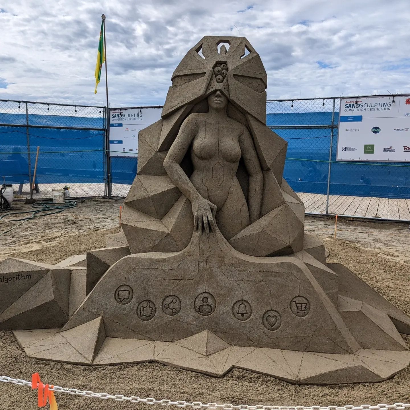 Futuristic sand castle art by Guy-Olivier Deveau shows a blind lady encased in geometric forms. 