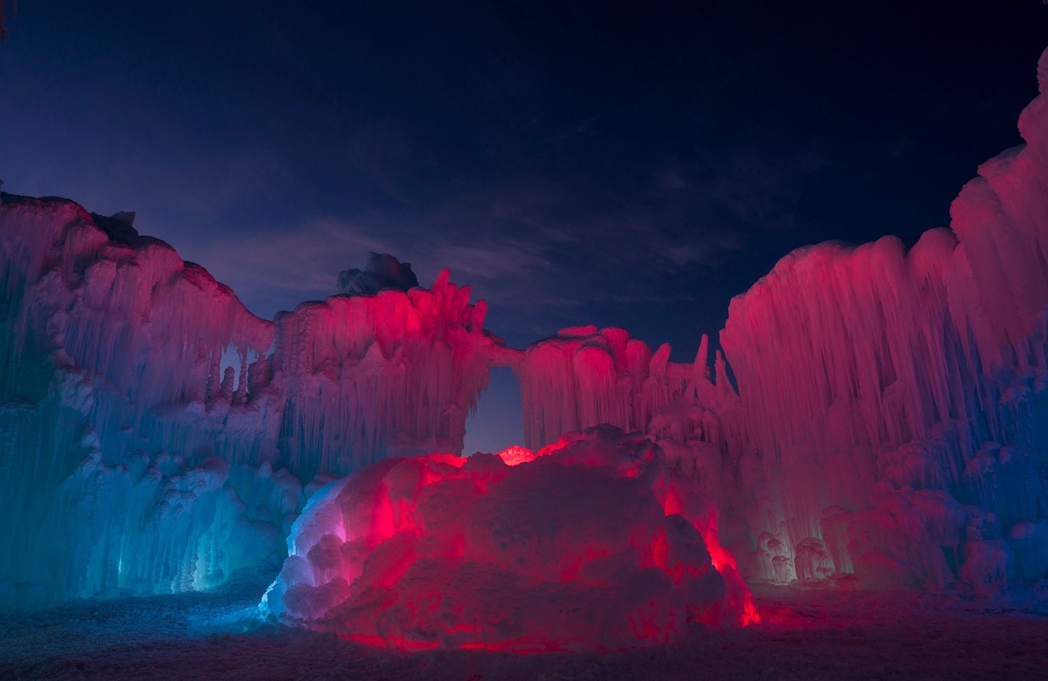 One of Brent Christensen's ice castles glows an ominous crimson shade in the cold winter evening.