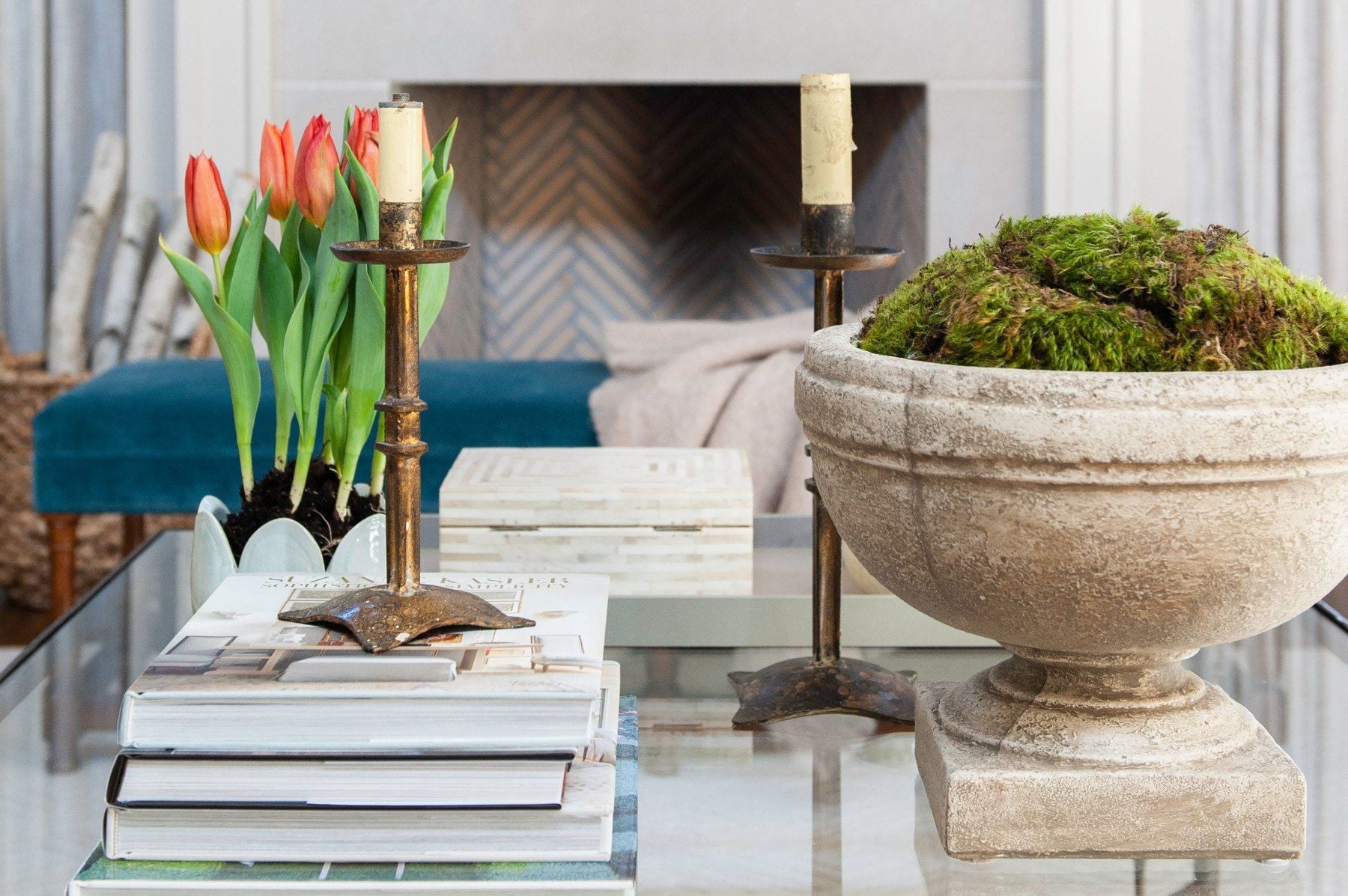 The textural contrast of this vignette (rough stone bowl, metallic candlesticks, thick paper books) can't help but draw the eye towards the scene.