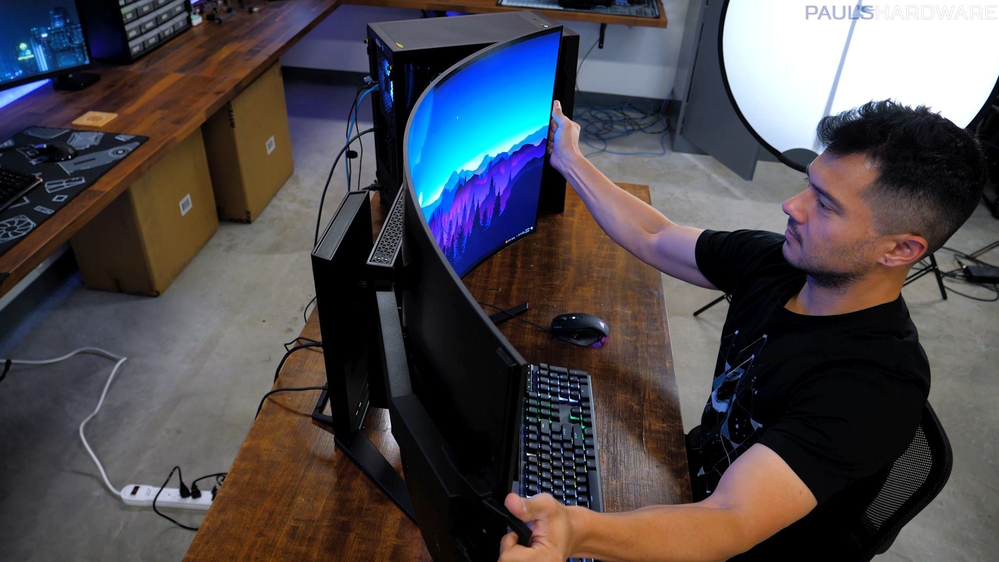 Man adjusts the curve of his Corsair Xeneon Flex gaming monitor.