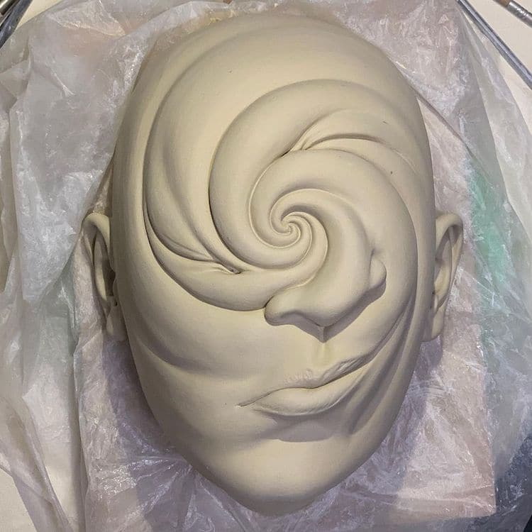 Surreal ceramic by Johnson Tsang shows a face twisting into itself.