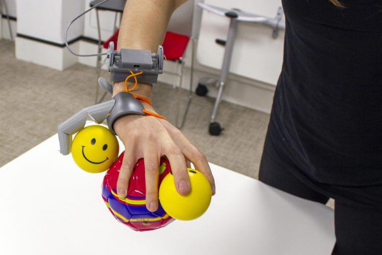 Third Thumb works in tandem with the real hand to hold several toy balls at once.