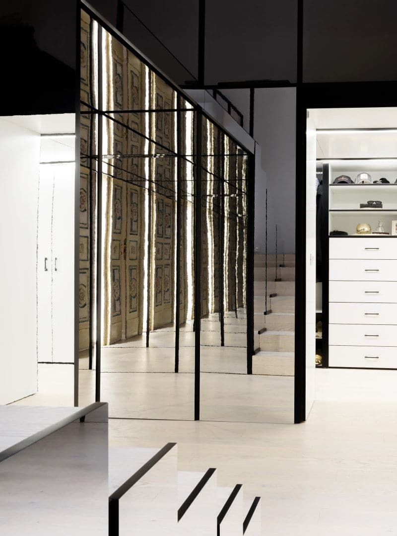 Mirrored built-in furniture element inside the Lelefante apartment opens to reveal a spacious walk-in closet.