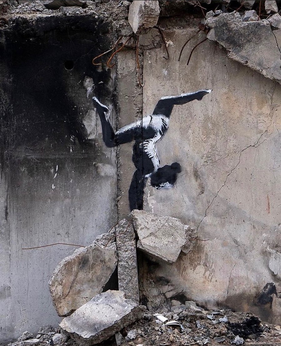 Banksy mural depicting a young gymnast performing a handstand on a pile of rubble outside a building devastated by shelling in Borodyanka, Ukraine.