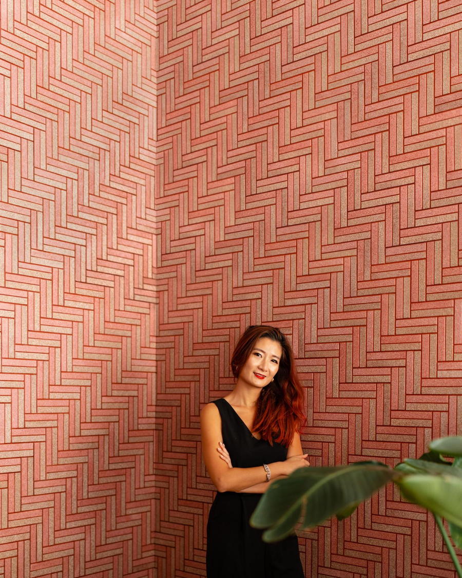 Designer Elaine Yan Ling Ng proudly stands in front of a wall of Carrelé eggshell tiles, produced in collaboration with Nature Squared.