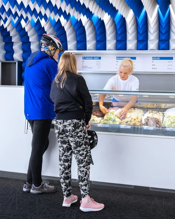 Young employee helps a couple at the shop's sleek Corian ice cream counter. 