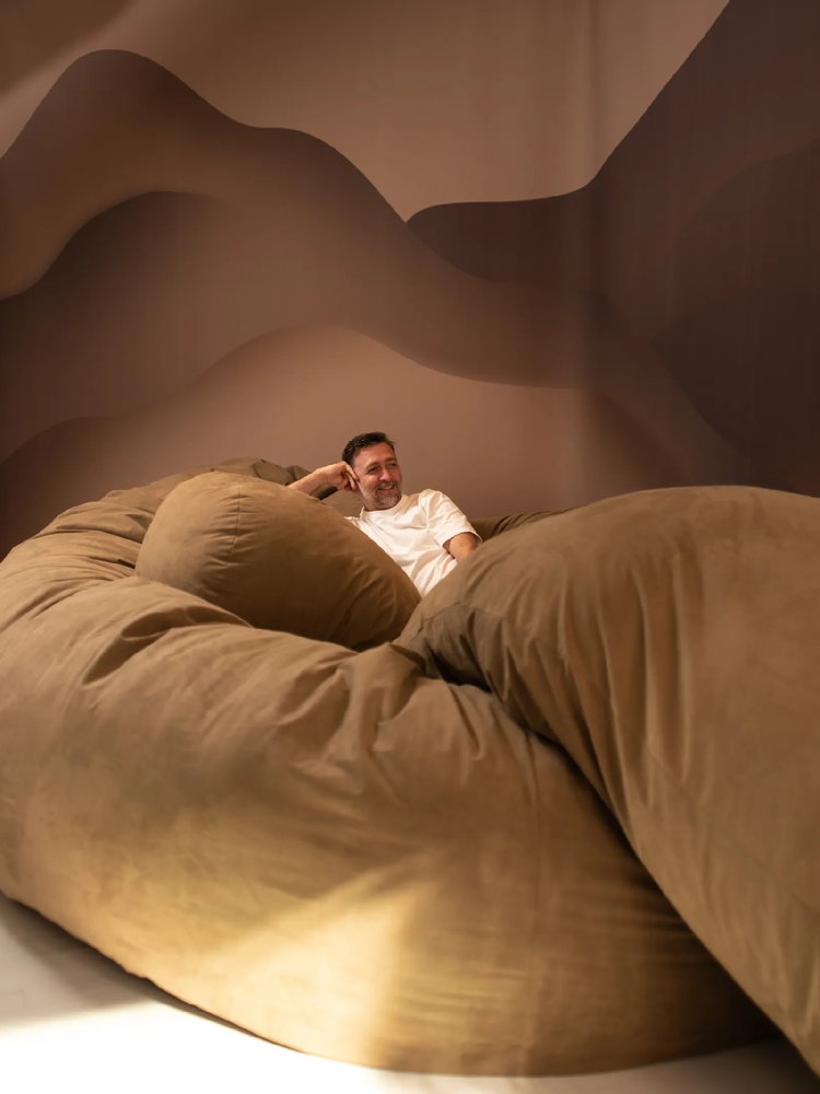 Designer Willo Perron reclines on his sculptural 