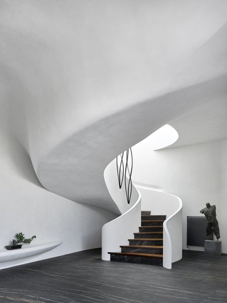 Sleek white walls and a curving spiral staircase make up the inside of the 
