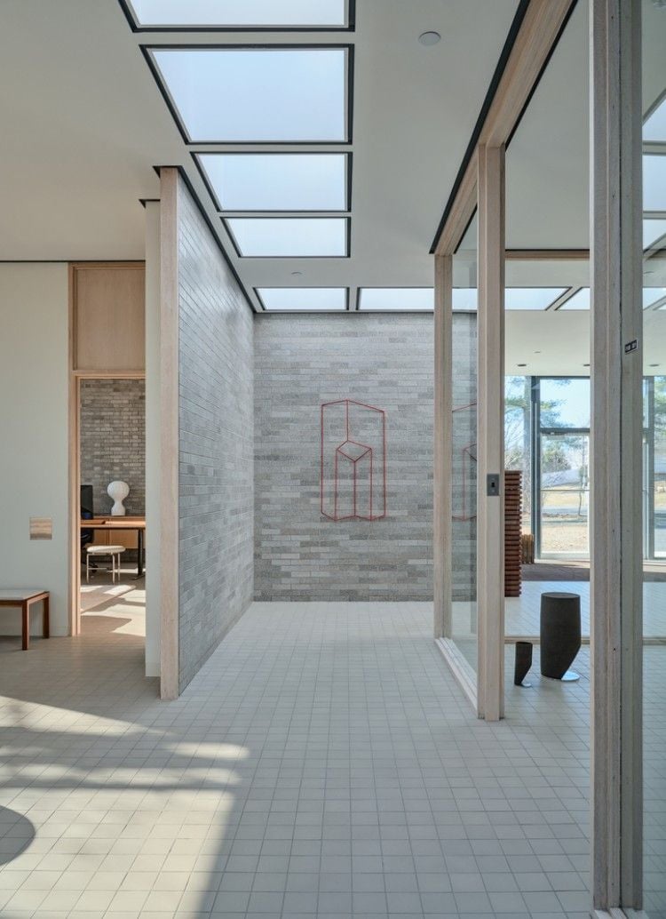an open stone and tile hallway with a wire frame abstract sculpture