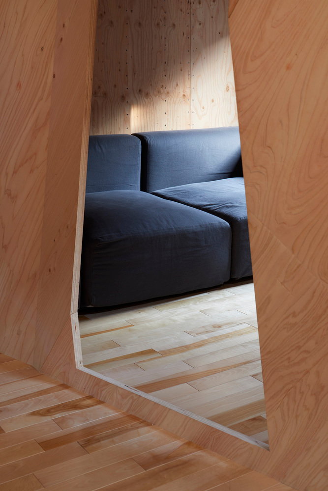 Cut-out in the tiny home's thin plywood walls creates separation without totally closing off distinct spaces. 