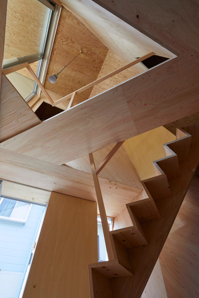 View up at the angular, staircase heavy interiors of Alphaville Architects 24-mm plywood tiny home in Kyoto.  