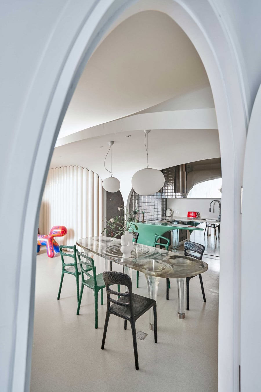 View into the Dreamscape apartment's dining area from behind a cruvy archway. 