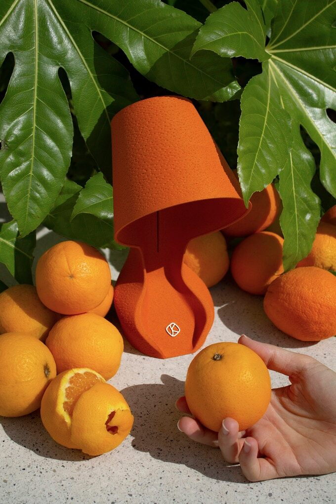 An Ohmie Orange Peel lamp surrounded by the same Sicilian oranges it's made from. 