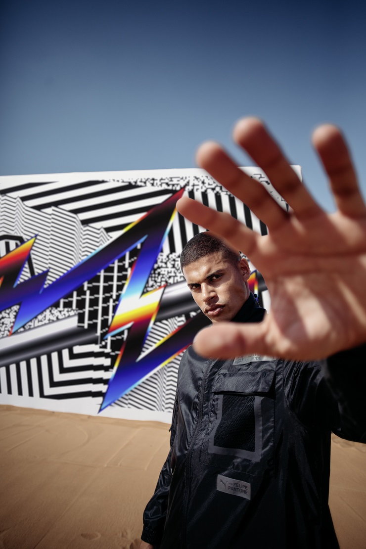 Artist Felipe Pantone stands in front of one of his creations.