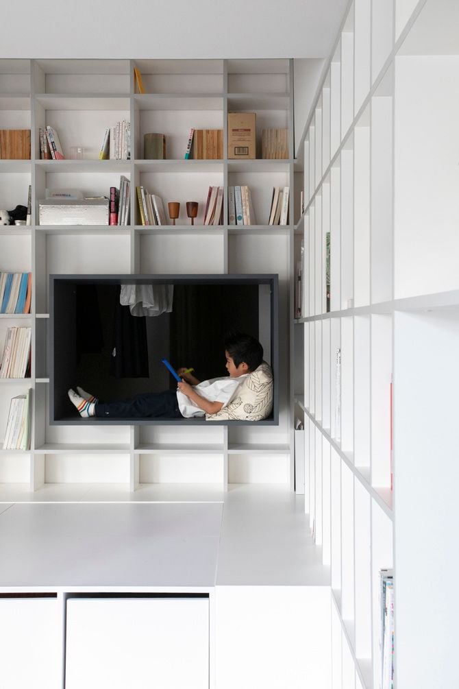 Child lounges in the reading nook frame inside his 