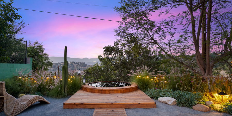 Sunken cedar tub in a Sarita Jaccard-designed backyard takes in the sunset surrounded by desert plants. 