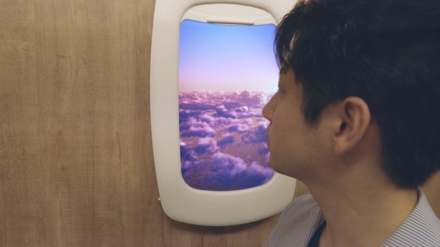 Man gazes out his Sky Scape Digital Airplane Window 