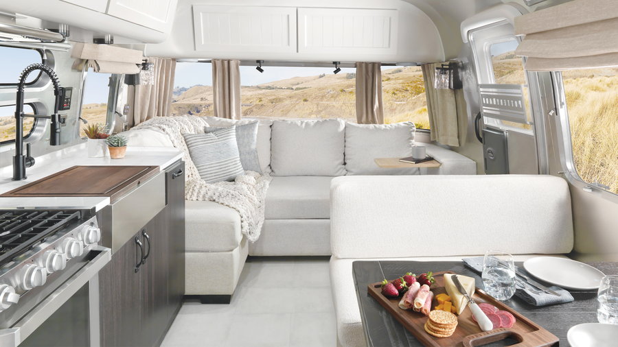 View of the cozy kitchen and living areas inside the new Airstream X Pottery Barn Travel Trailer
