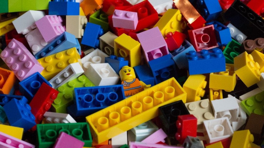 LEGO Minifig lost in a sea of building blocks.