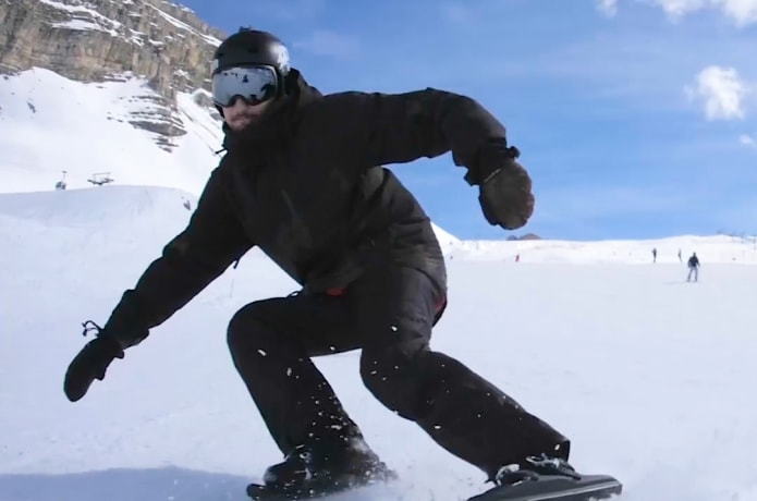 Man shreds down the slopes on his ultra-compact Snowfeet attachments.