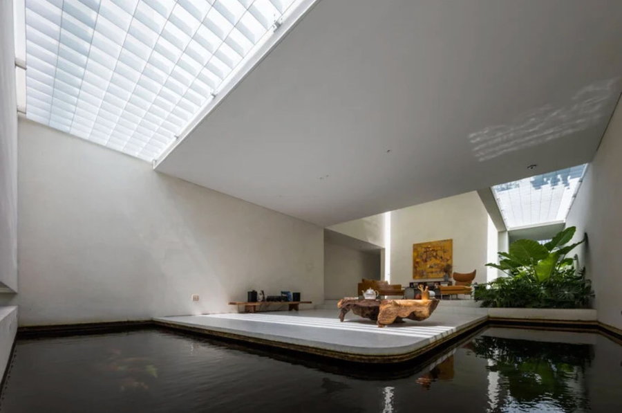 Tranquil koi pond wraps around the light-filled living area of Ho Chi Minh City's 